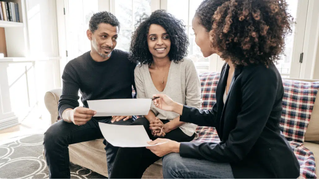 Image of a man and woman sitting on a couch discussing a home mortgage document.