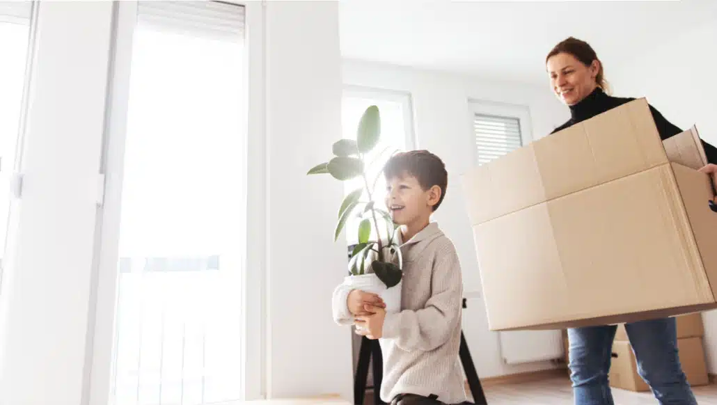 Mother and young son moving boxes into their quick delivery home