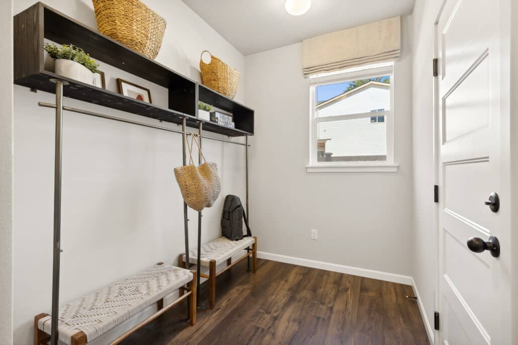 Interior mud room with seating and a window out to side of the home.