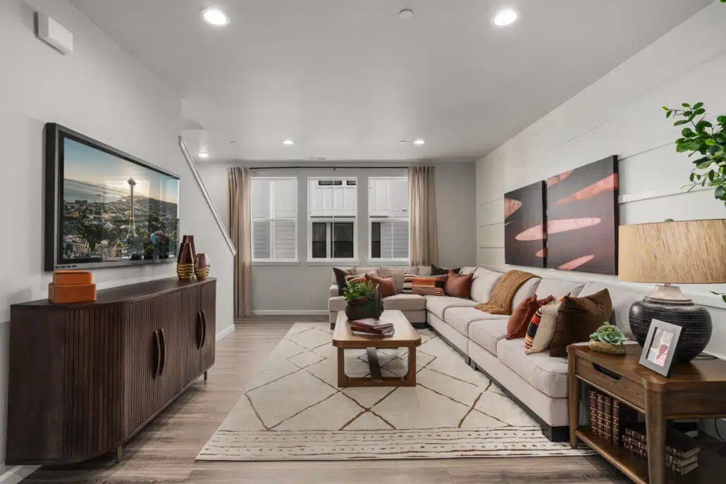A living room with a grey couch and wood furniture.