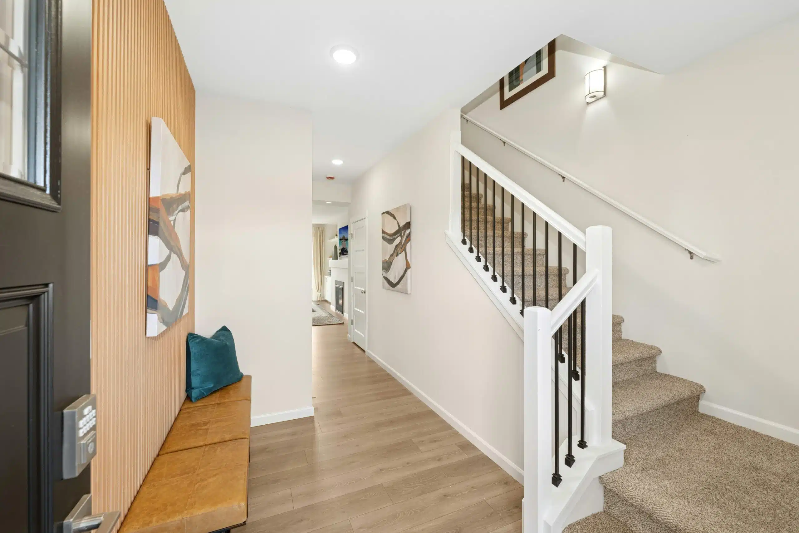 Front entry area with a bench on the left and stairs on the right in the Sparrow model of the Crystal Springs community.