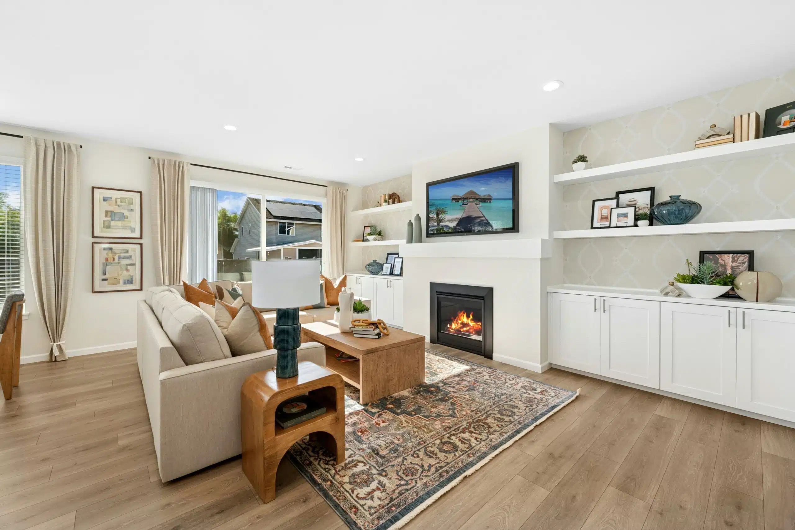 Open living are with built-in bookcases, a fireplace, and wood flooring