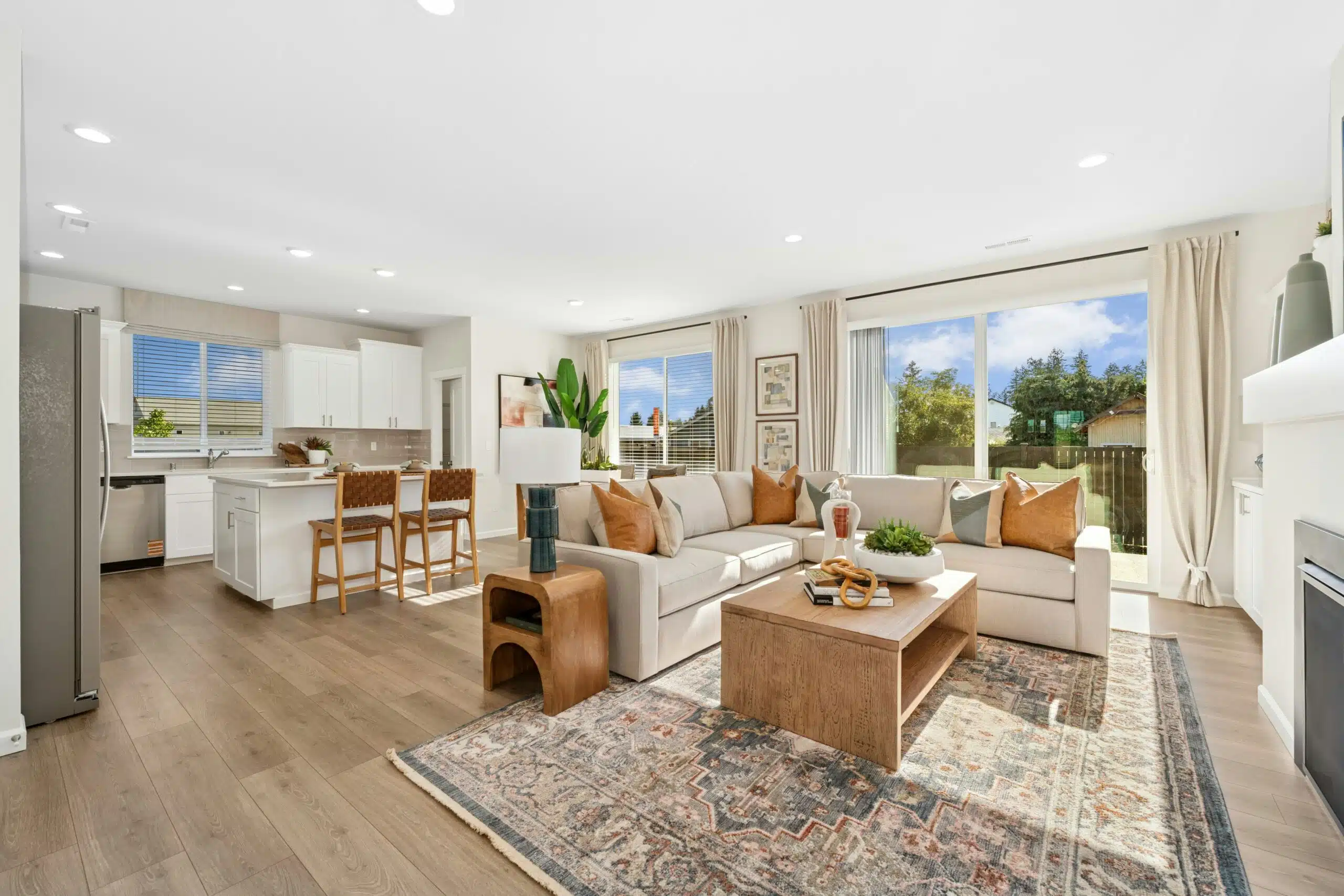 Open kitchen/dining/living area with large windows out to the backyard.