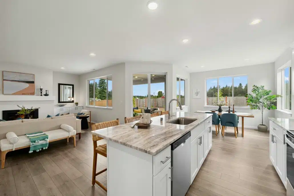 Open-concept kitchen with a large island, stainless steel appliances, and a dining table by the window.