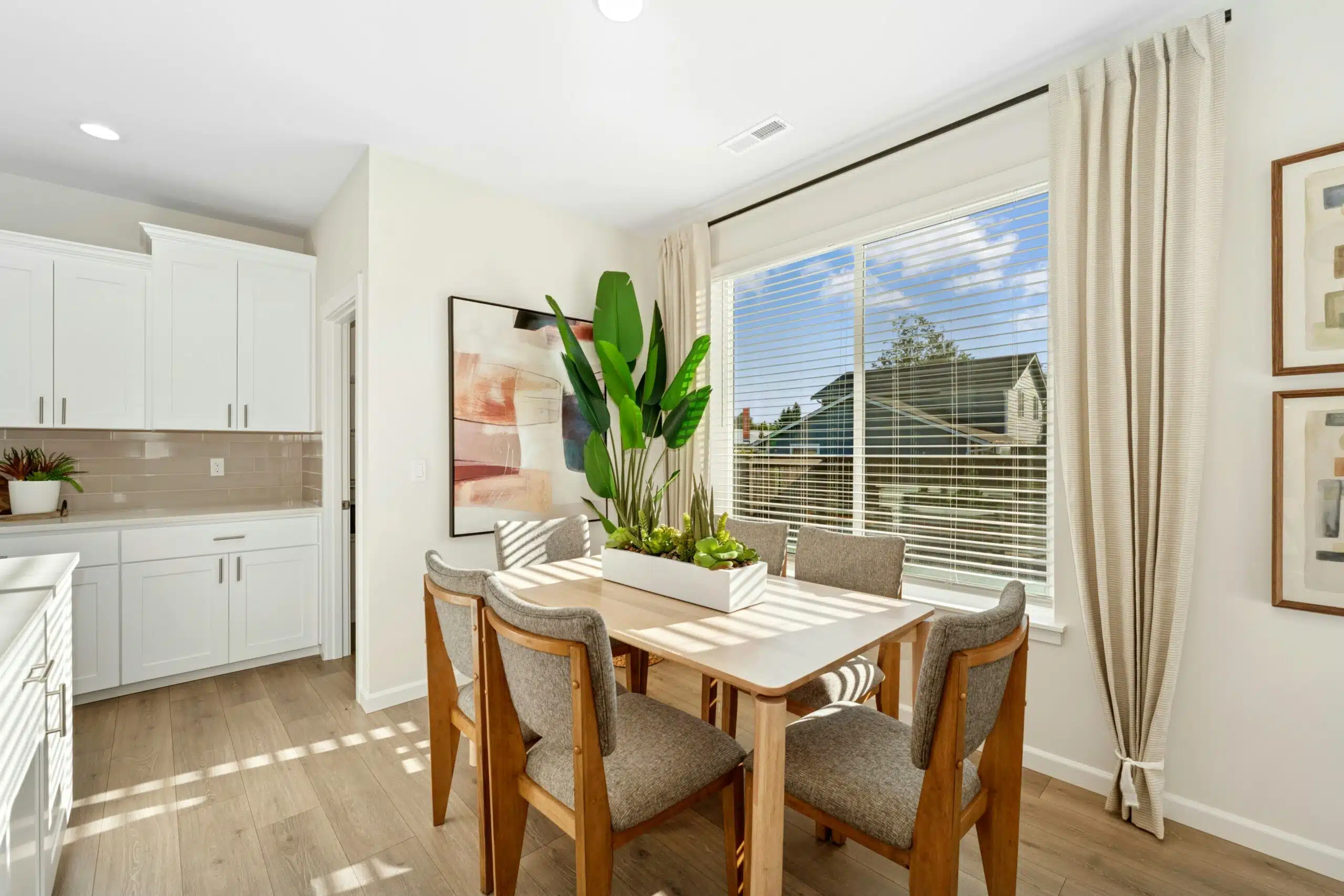 Small dining table for 6 next to a large window facing the backyard.