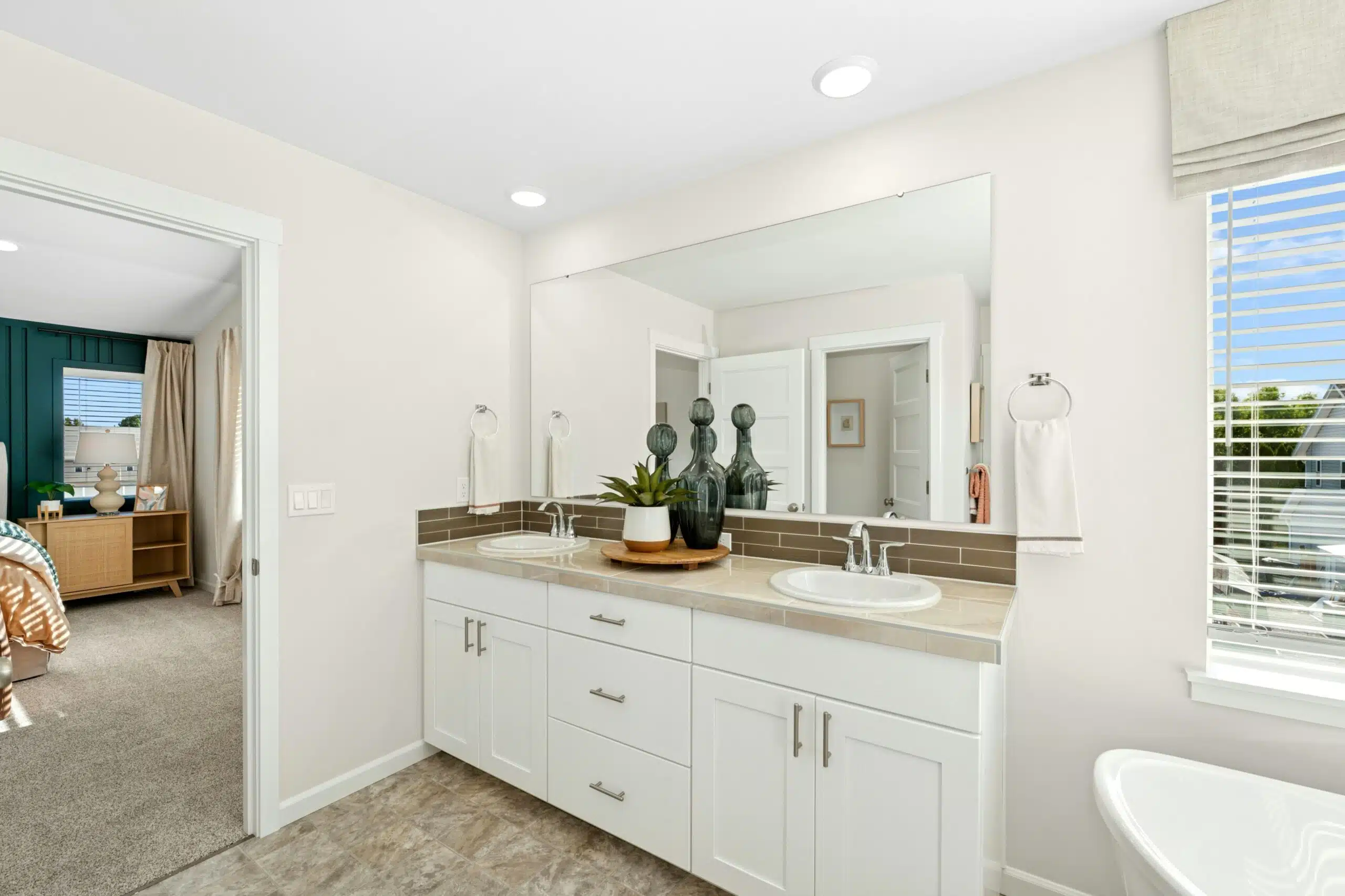 Double vanity with white cabinets and tile flooring.
