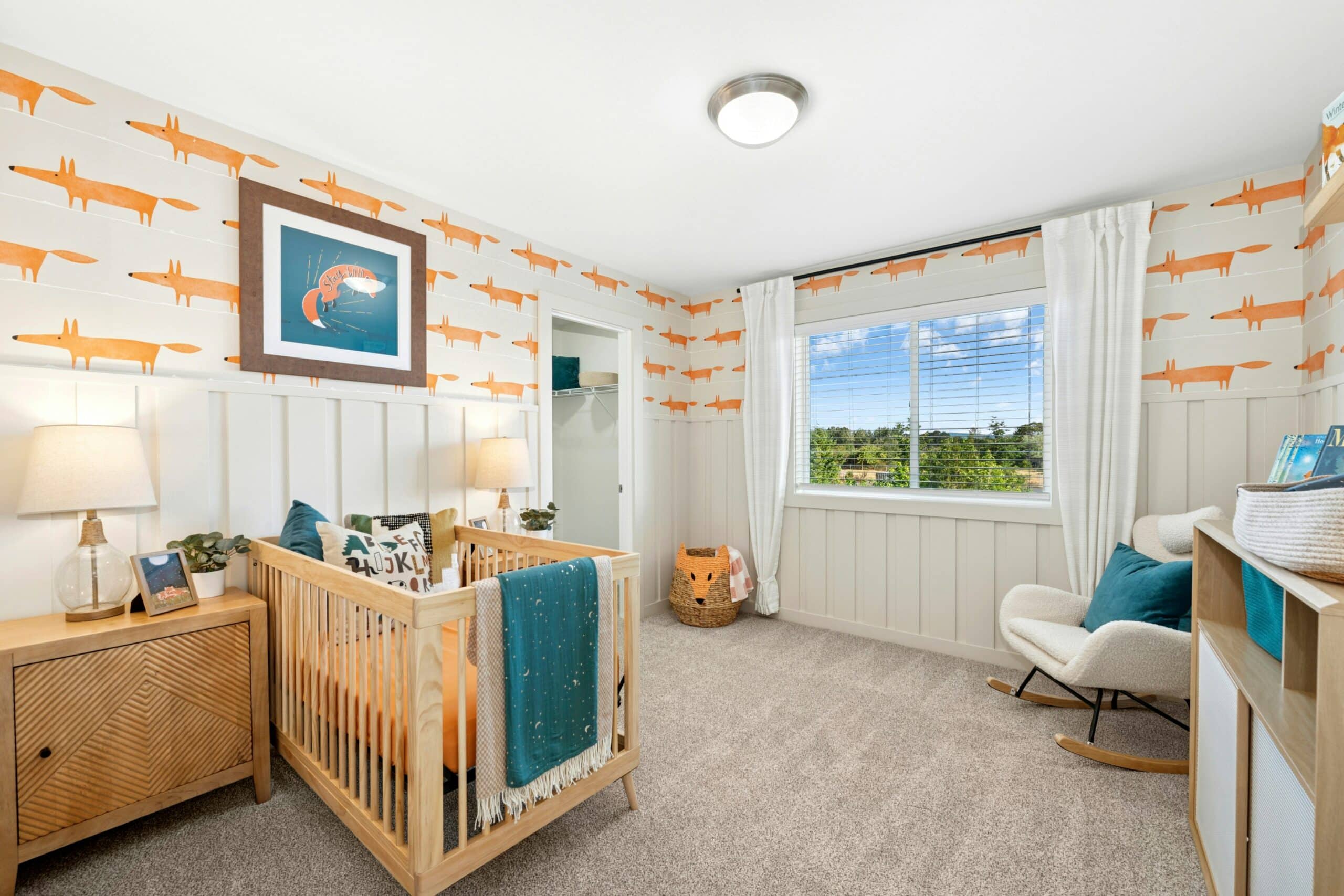Carpeted bedroom with a crib and large window.