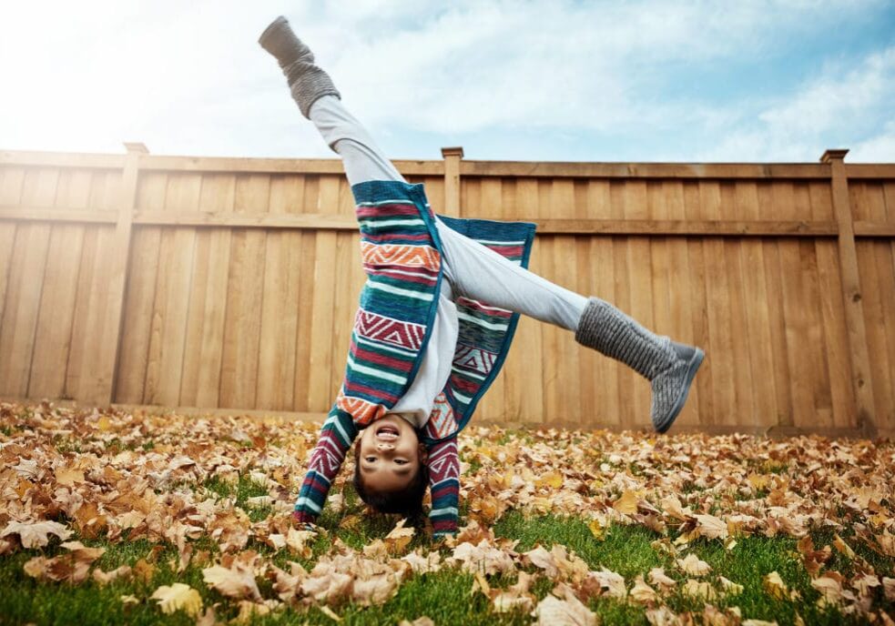 Shot of an adorable little girl doing cartwheels an autumn day outdoors